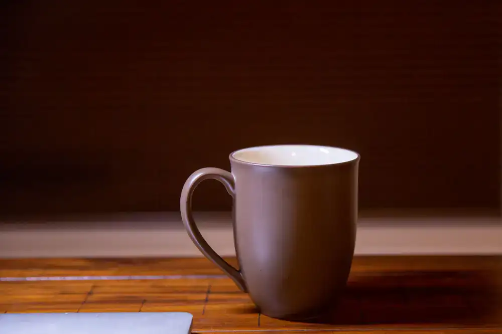 A warm mug of classic black tea on a wooden table