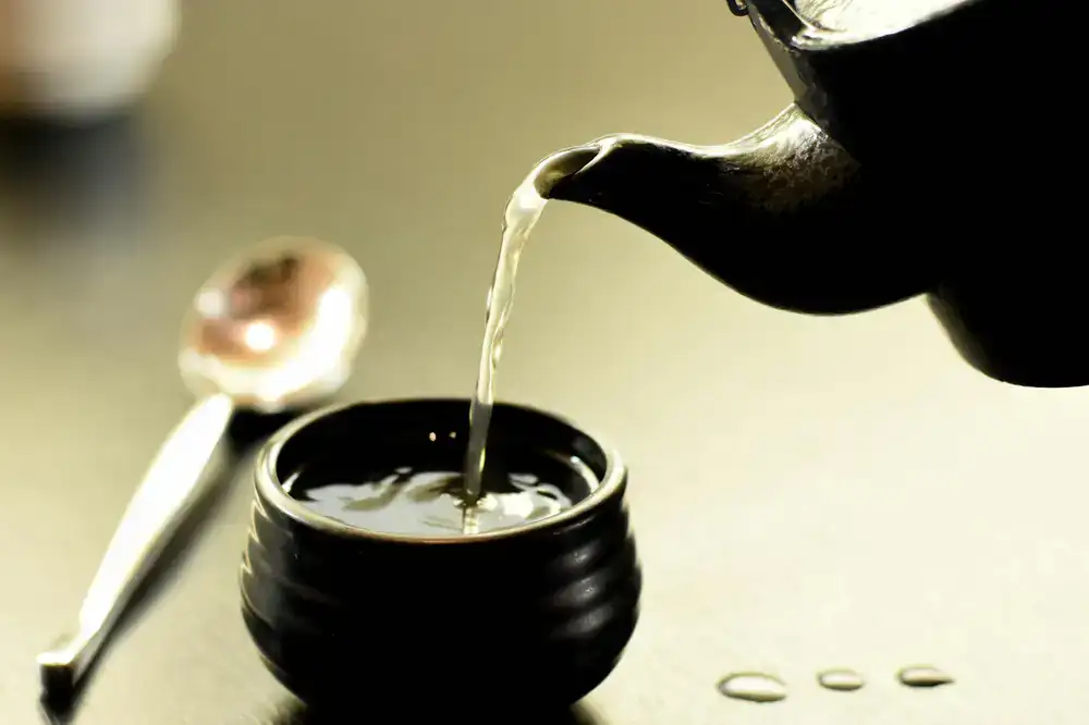 Hot water being poured from a clay teapot